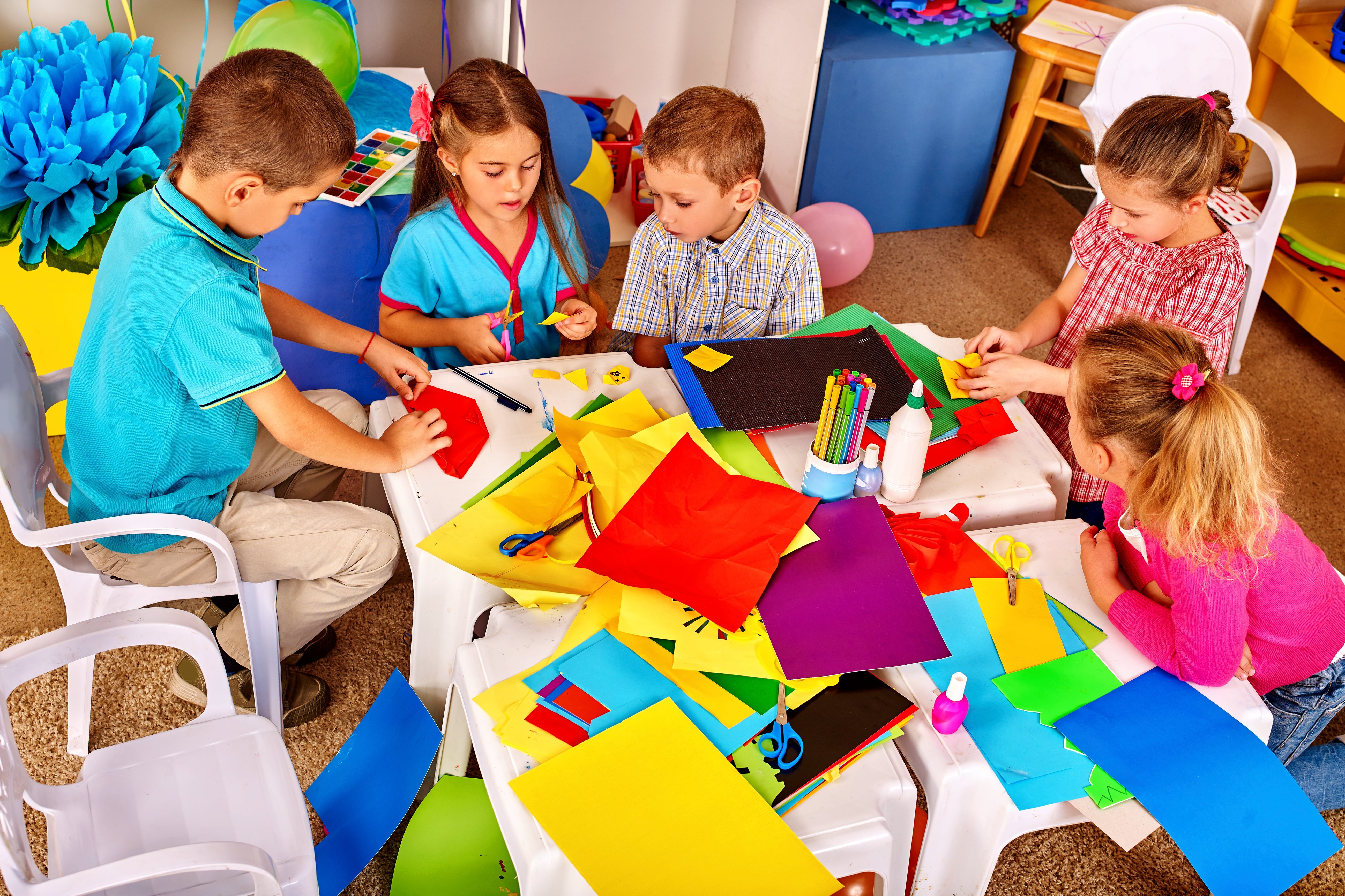 Children use colored paper for creativity.