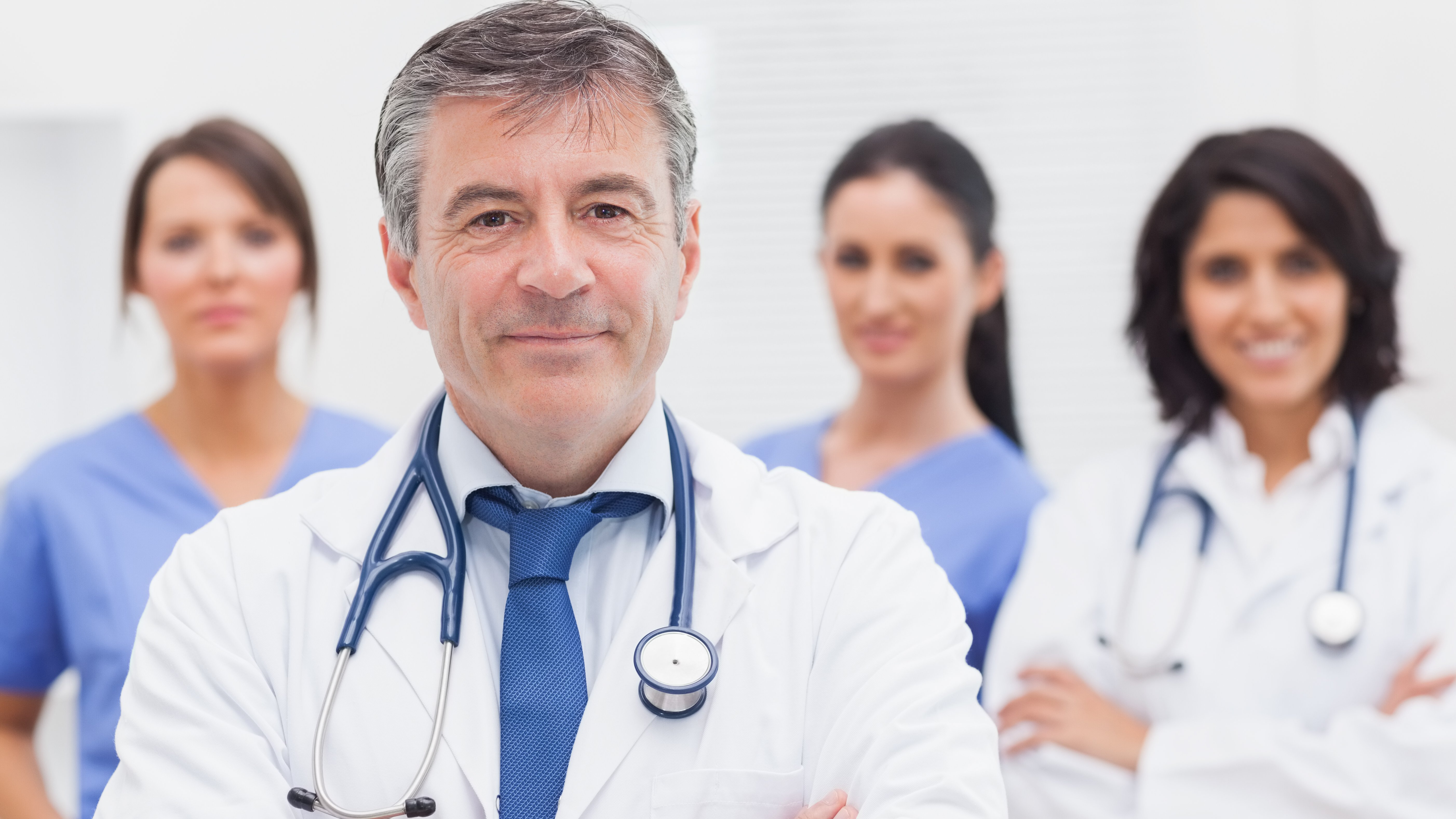 Doctor and his team smiling at camera