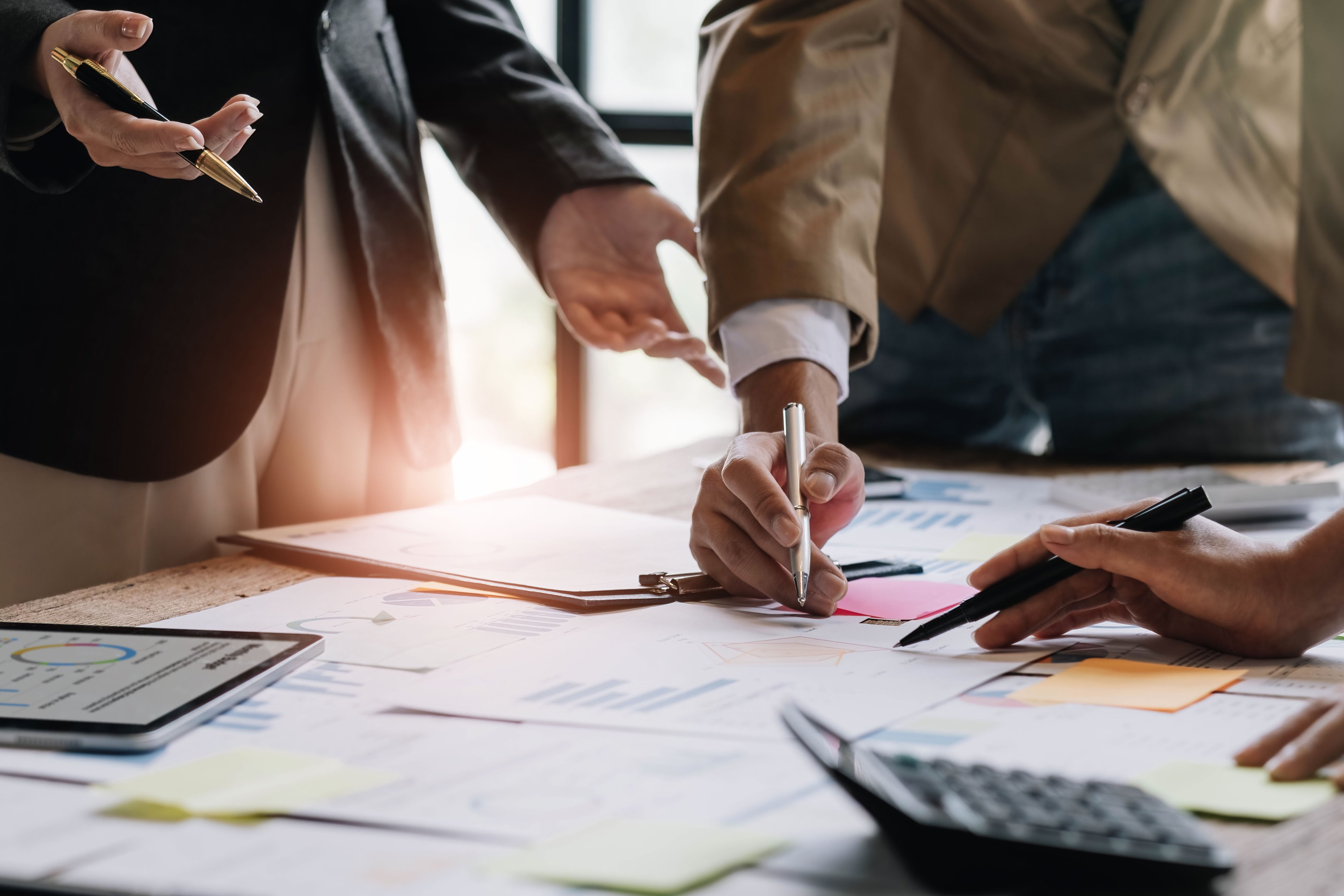 Business People Meeting using laptop computer,calculator,notebook,stock market chart paper for analysis Plans to improve quality next month. Conference Discussion Corporate Concept