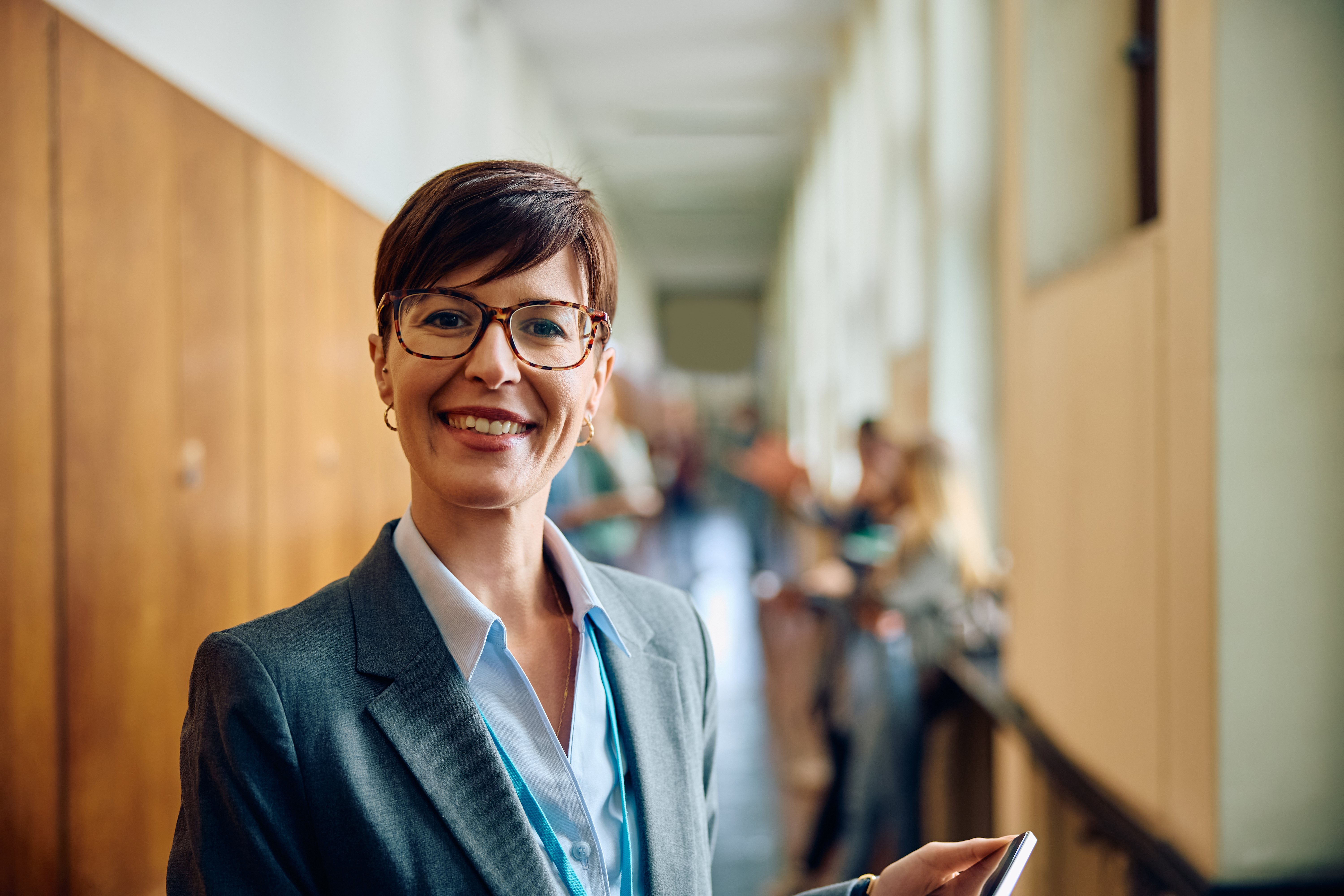 Portrait of happy female professor at school looking at camera.