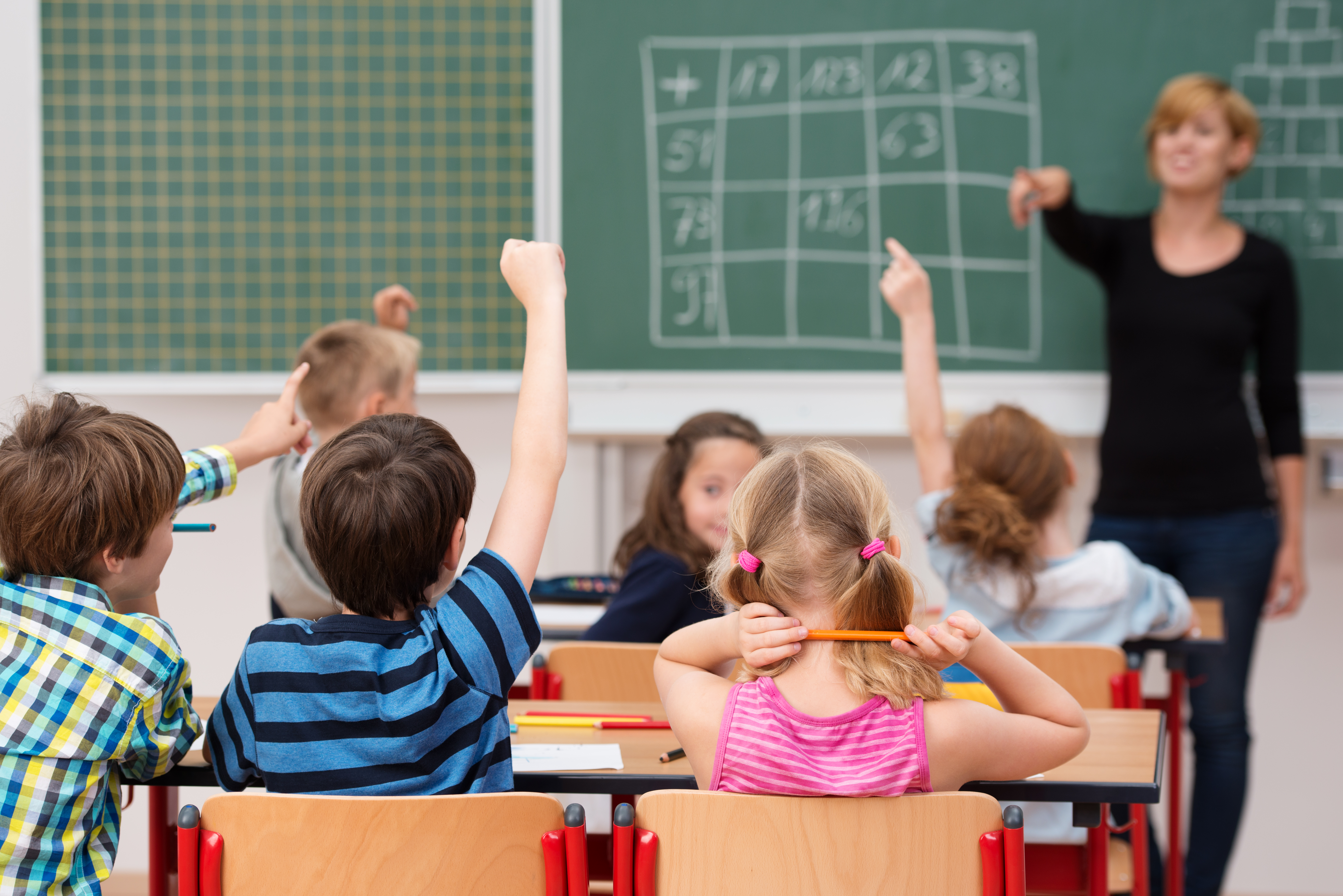 Young boy answering a question in class